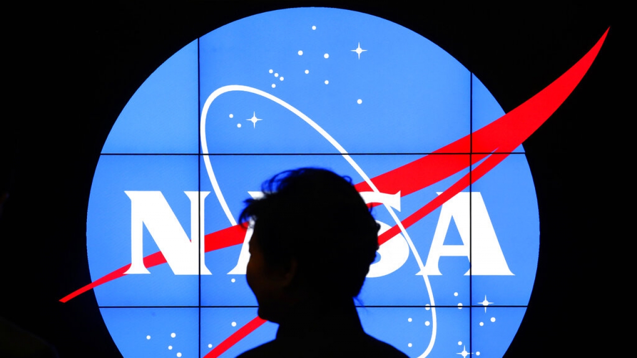 Former South Korean President Park Geun-hye walks past a NASA logo.