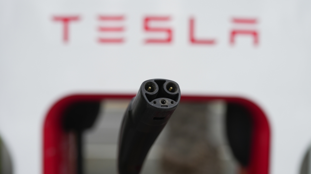 Tesla's EV charging connector is pictured at a charging station.