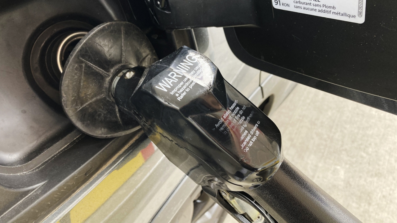 A fuel pump nozzle is seen at a gas station.