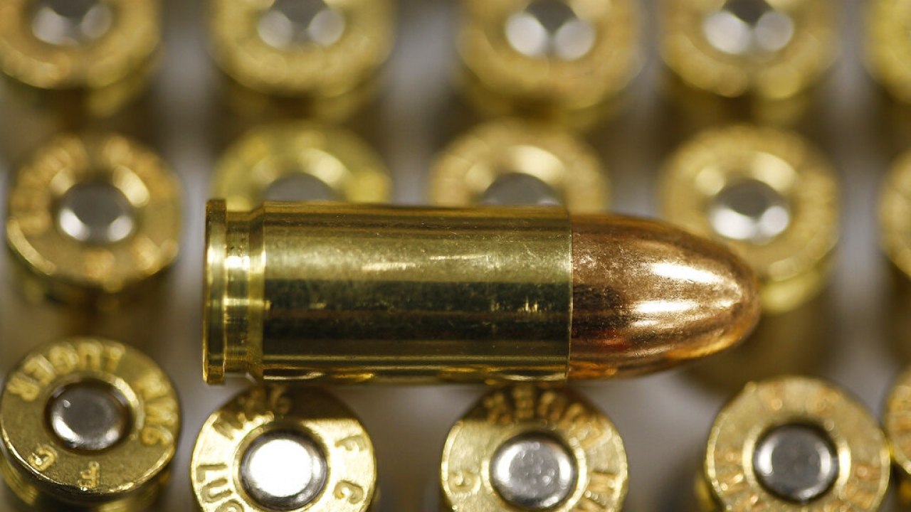 A 9 mm bullet rests on top of others in a box