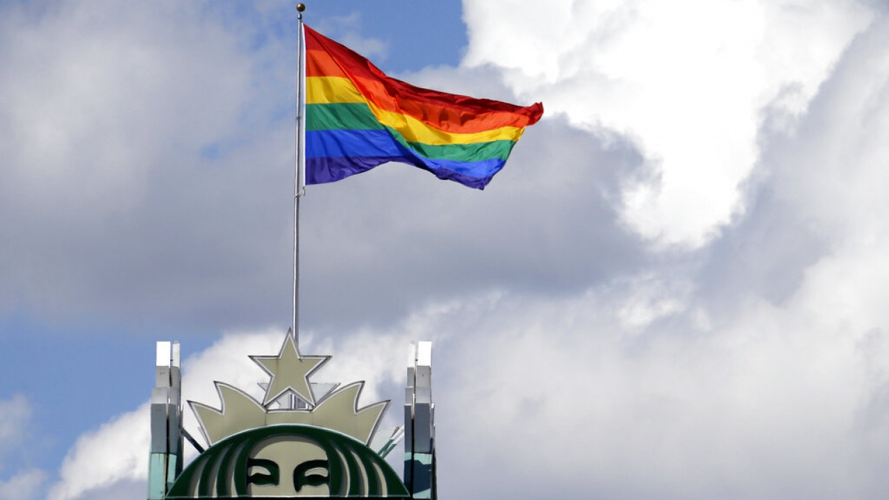A giant Pride flag flies atop the Starbucks headquarters.