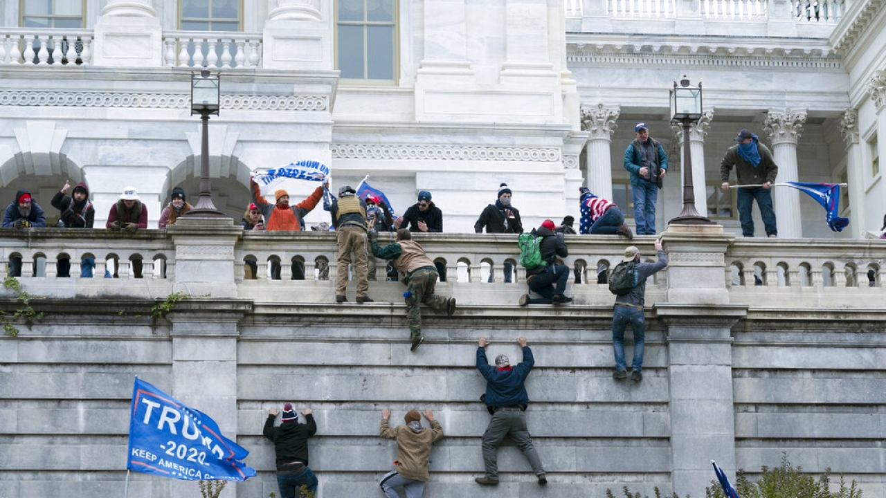 Insurrectionists scale the west wall of the the U.S. Capitol in Washington.