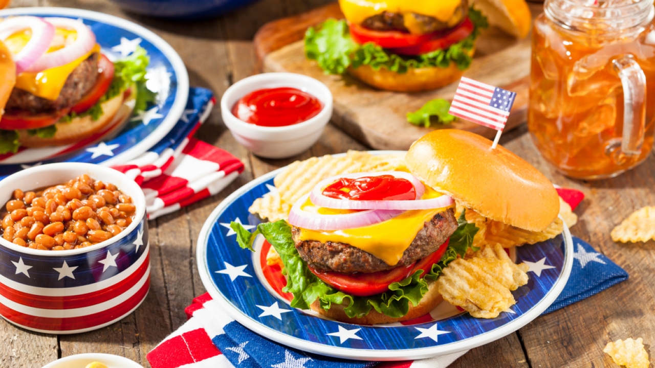 Fourth of July cookout items, including a cheeseburger, chips, beans and ketchup.