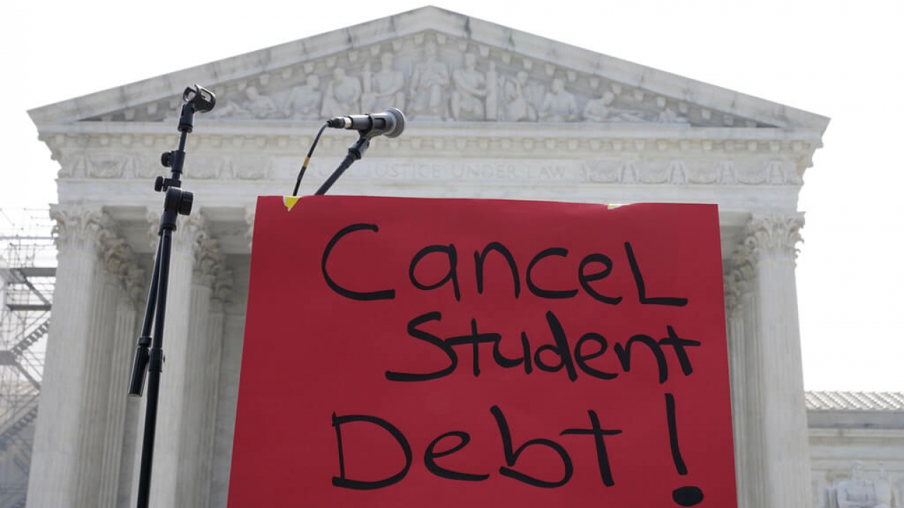 A sign reading "cancel student debt" is seen outside the Supreme Court.