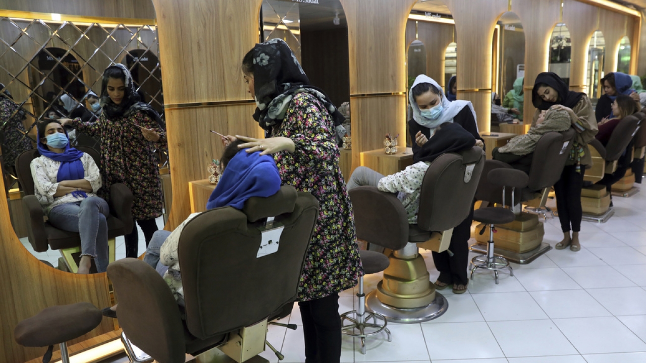 Beauticians put makeup on customers at Ms. Sadat's Beauty Salon in Kabul, Afghanistan