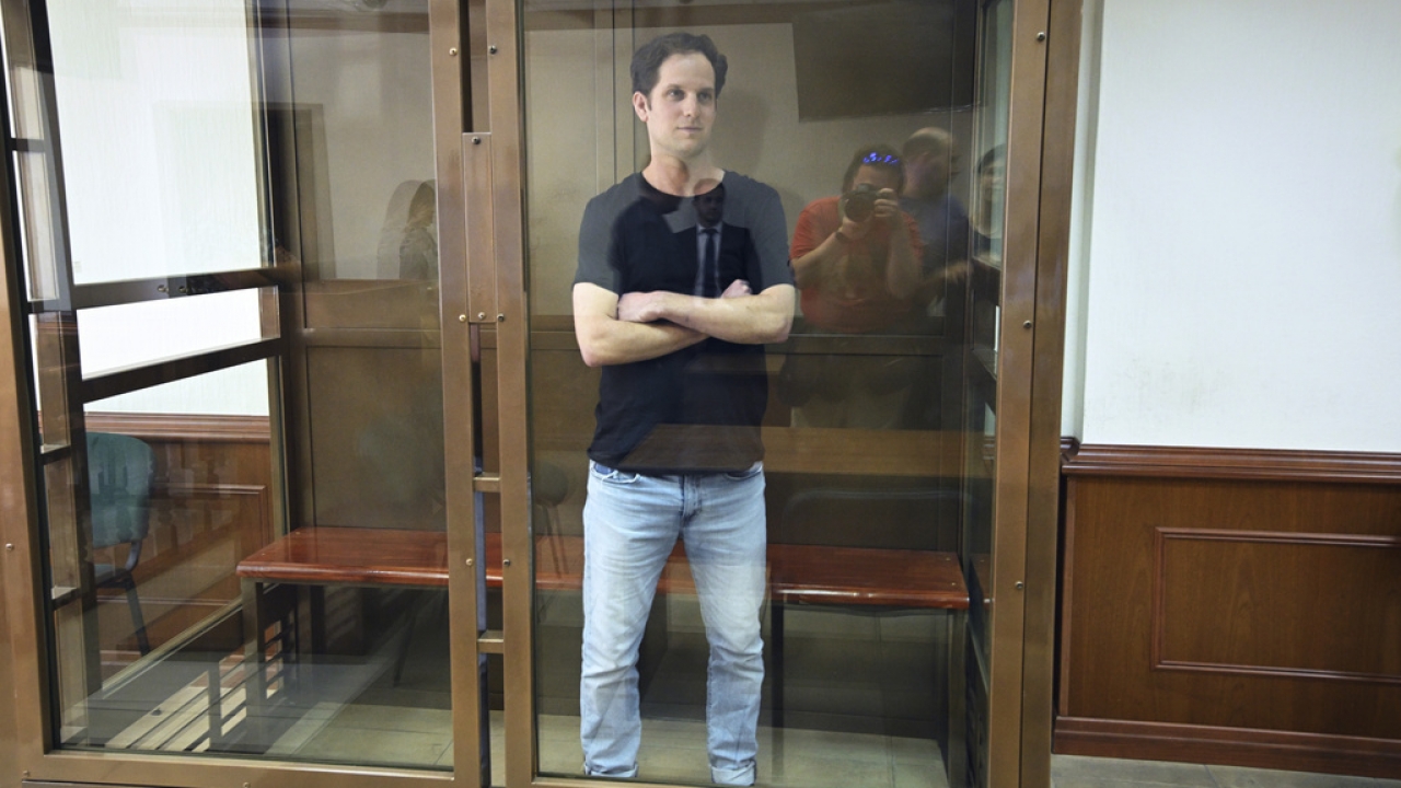 Wall Street Journal reporter Evan Gershkovich stands in a glass cage.