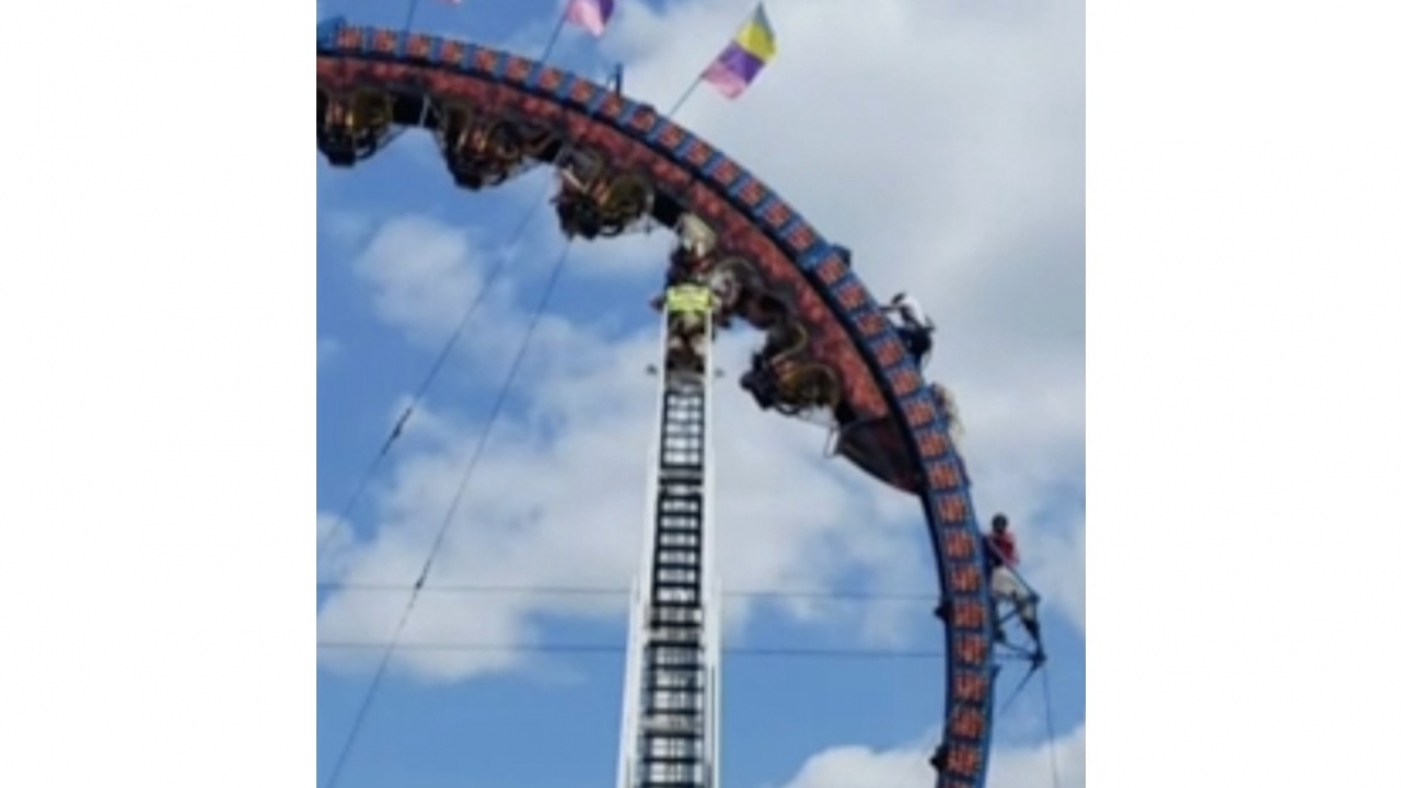 Rescue teams work to remove riders trapped on a roller coaster