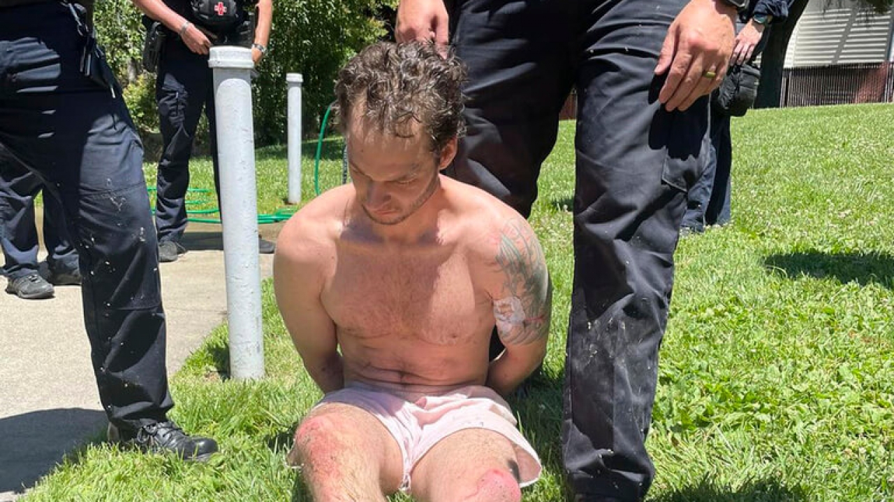 Eric Abril sits after being taken into custody by police in Rocklin, Calif.
