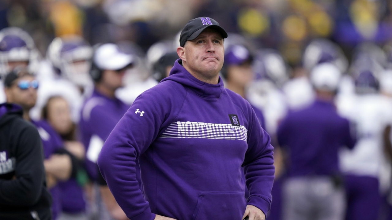 Northwestern head coach Pat Fitzgerald stands on the sideline during the first half of an NCAA college football game.