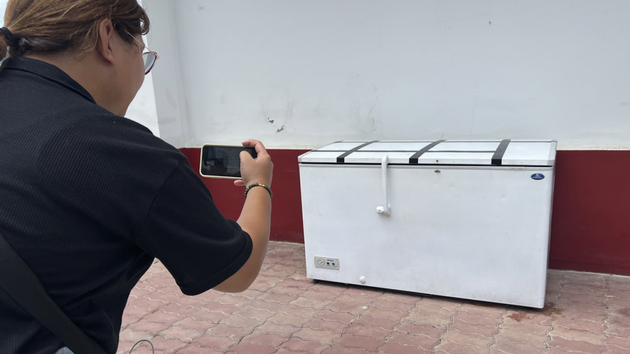 A Thai reporter takes a photo of an empty freezer.
