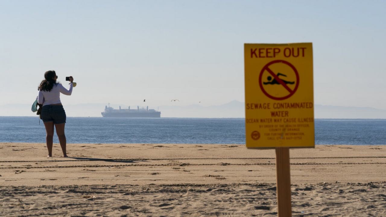 Sign on a beach warning of sewage contaminated water.