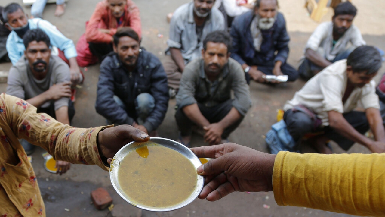 People wait for free food outside an eatery in Ahmedabad, India.