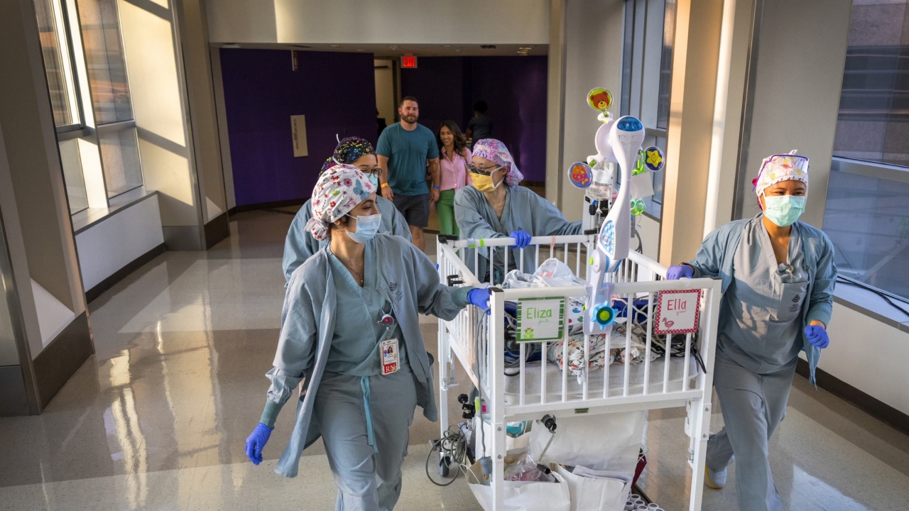 Doctors cart formerly conjoined twins Eliza and Ella after their surgery.