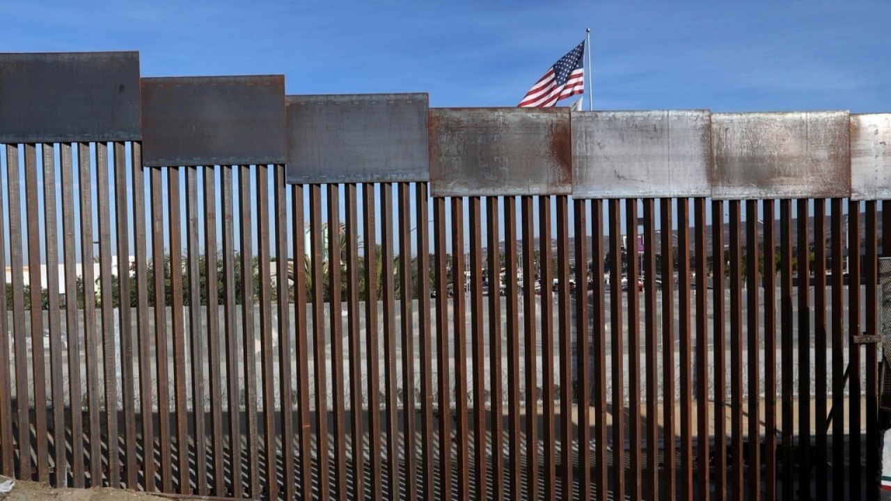A United States flag flies behind the border fence that divides Mexico and the U.S.