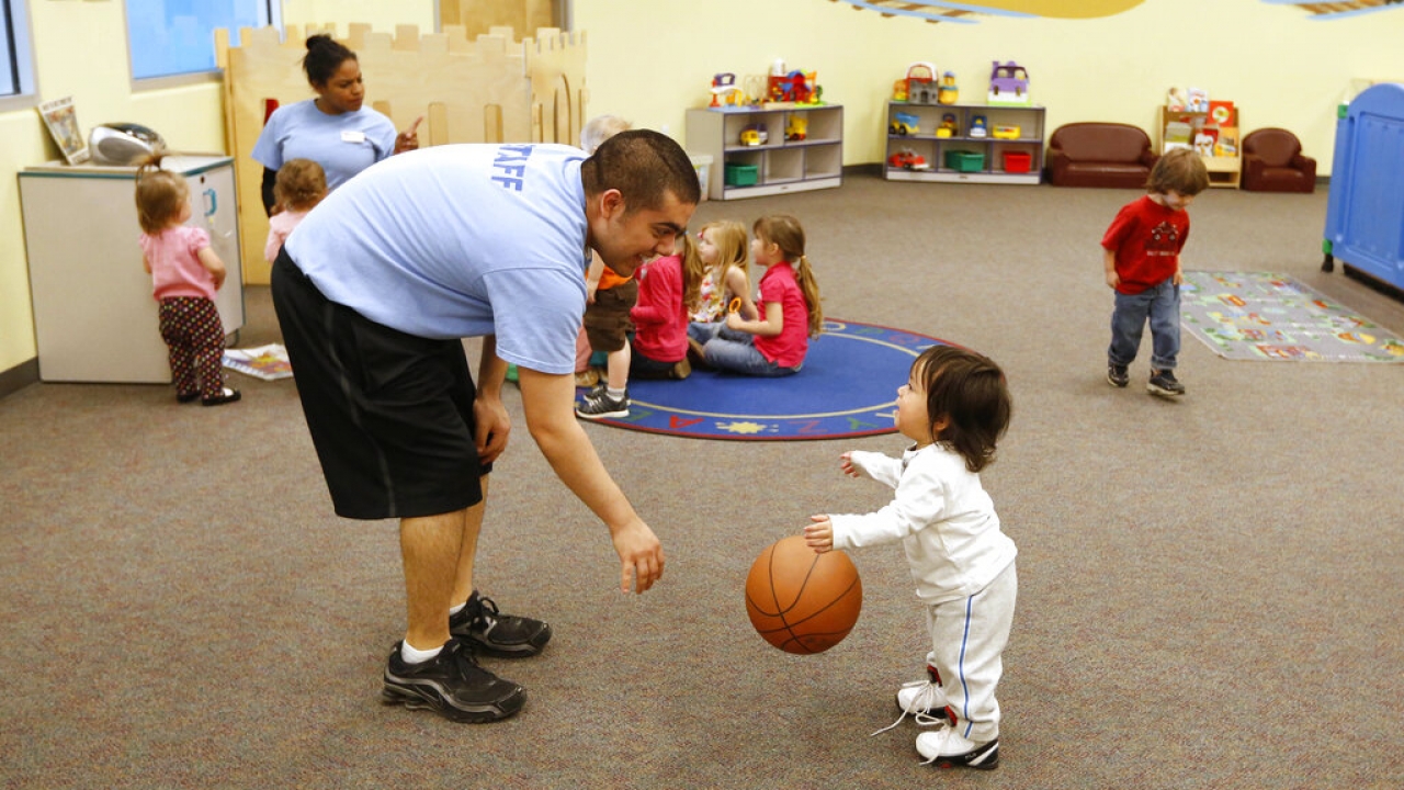 An employee of the child care center at the California Family Fitness center, plays with a toddler.