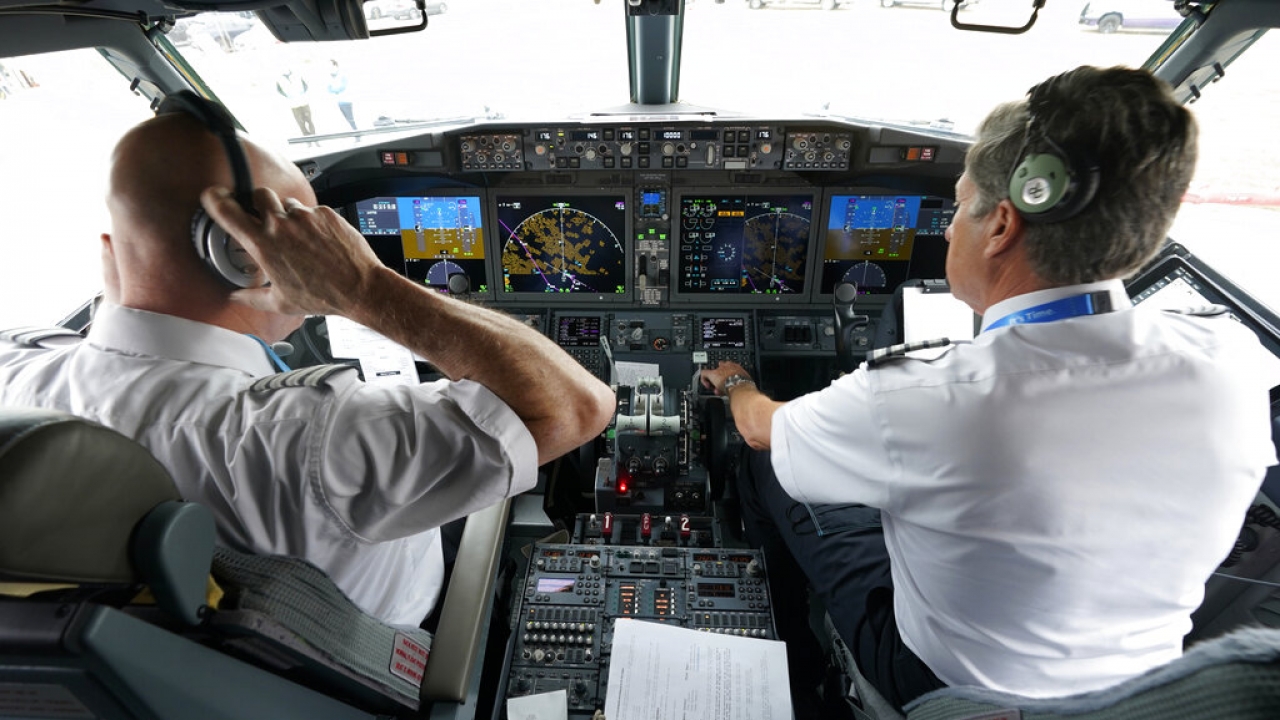 Pilots conduct a pre-flight check in the cockpit of a Boeing 737 Max jet.
