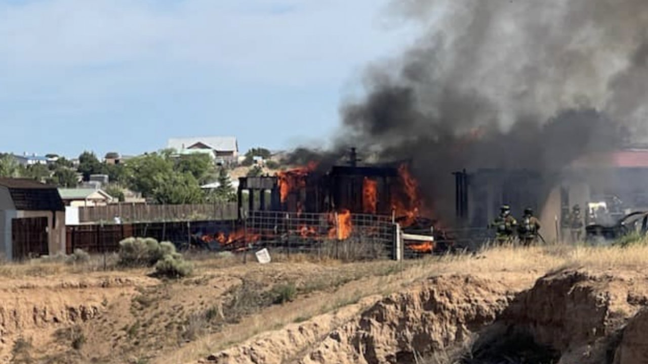 A house near Santa Fe, New Mexico, fully engulfed in flames after a plane crashed into it.