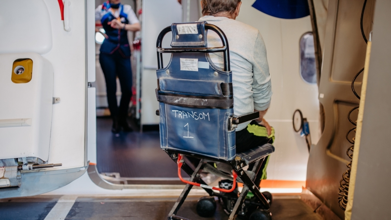Person in wheelchair entering airplane.