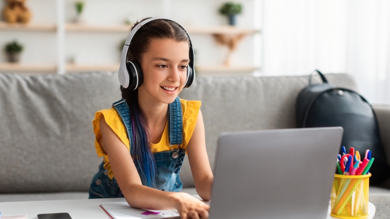 Girl using laptop and headphones.