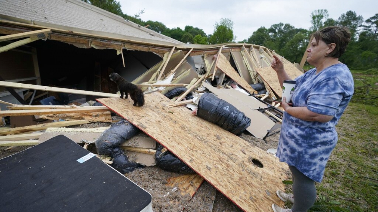 A woman looks at the remains of her mobile home