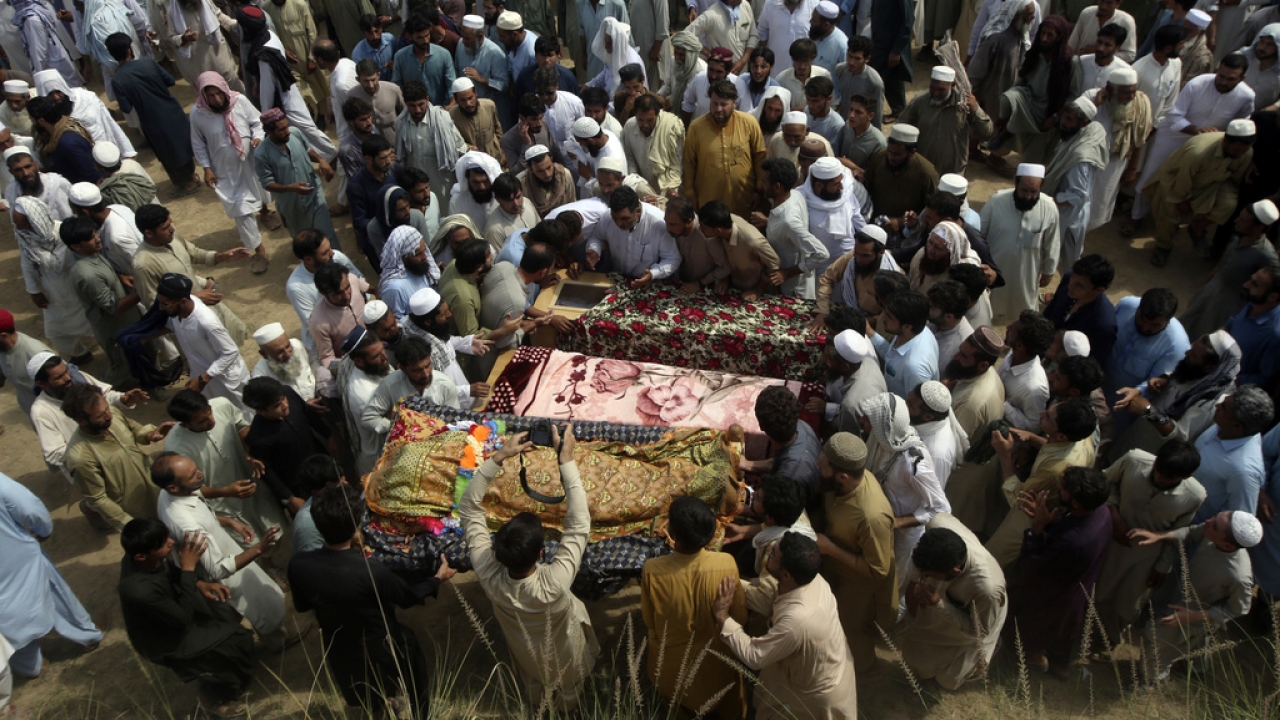 Relatives and mourners gather around the caskets of victims who were killed in Sunday's suicide bomber attack in Pakistan.