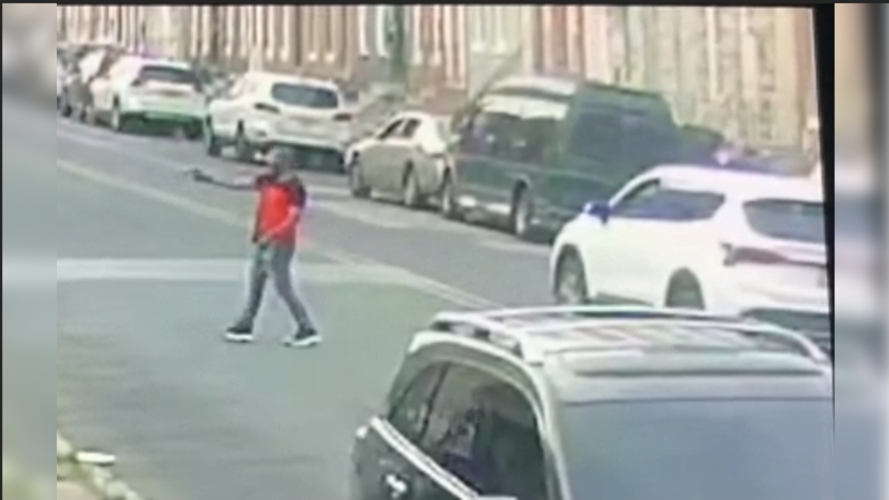 Still taken from surveillance footage shows a man aiming a gun.