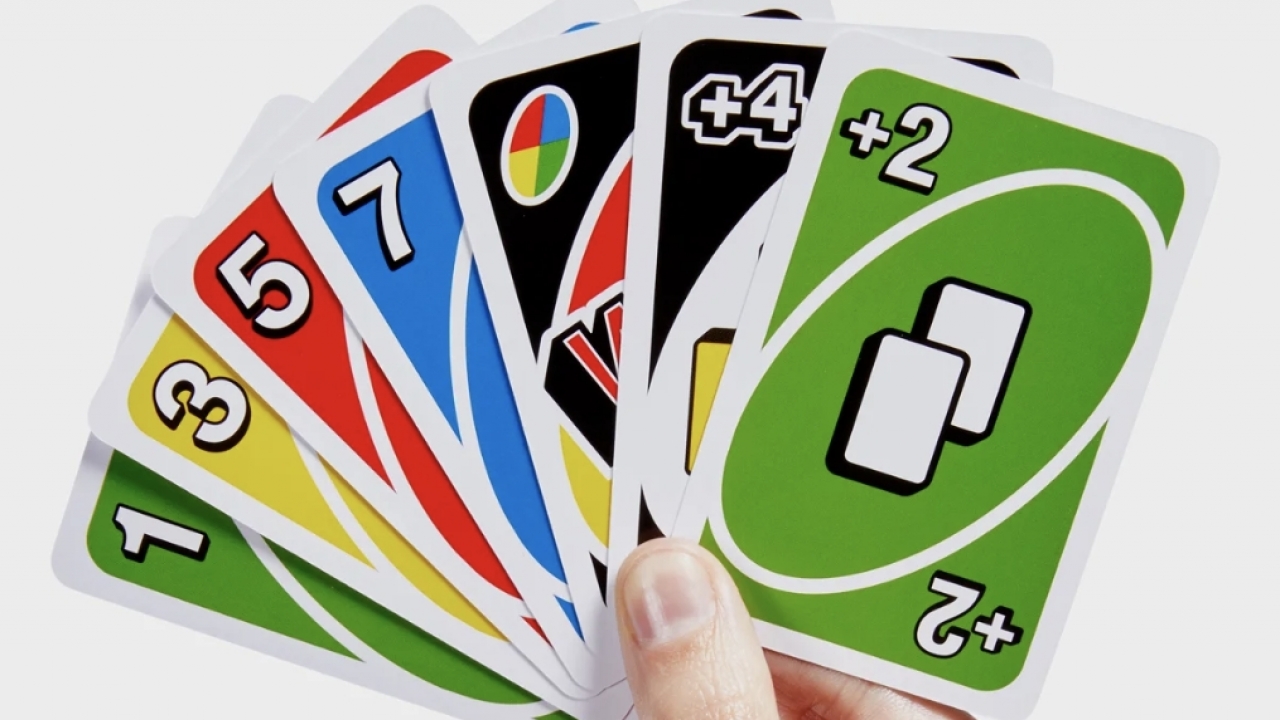 Person holding Uno cards.