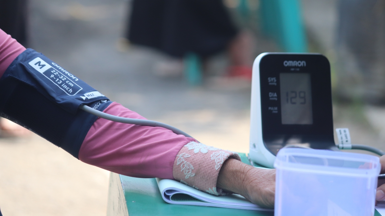 A person uses a blood pressure measurement device.