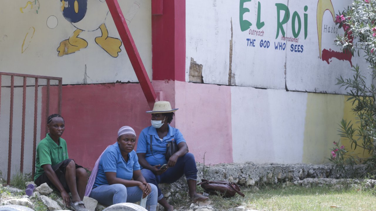 Staff sit in front of a school funded by El Roi Haiti.