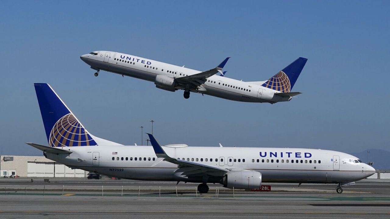 United Airlines airplane takes off over a plane on the runway.