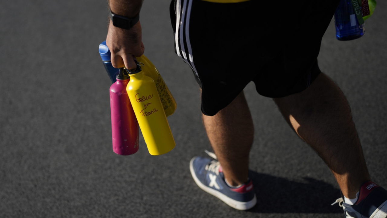 A volunteer carries bottles of water.