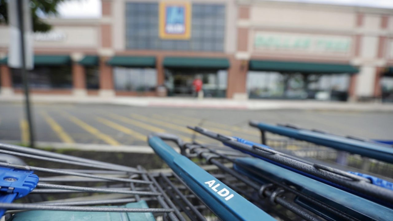 Shopping carts are lined up on the parking lot of an Aldi supermarket.