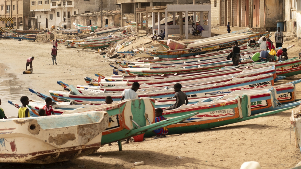 Children play on fishing boats known as "pirogues" in Dakar, Senegal.
