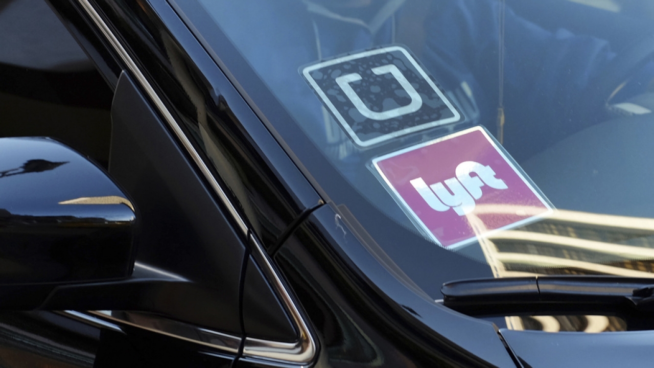 A Lyft sign is displayed in a driver's car