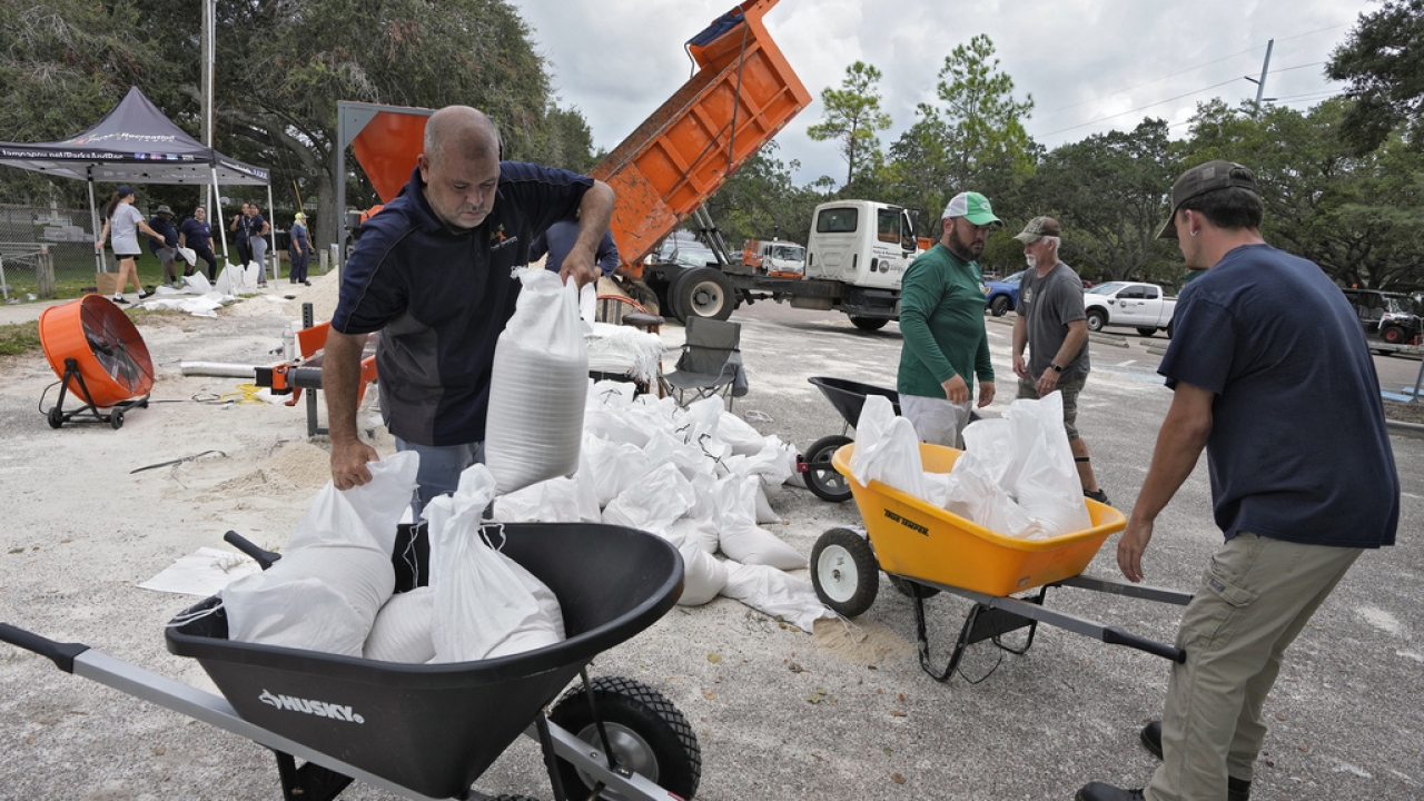 Members of the Tampa Parks and Recreation Department in Florida help residents fill sandbags.