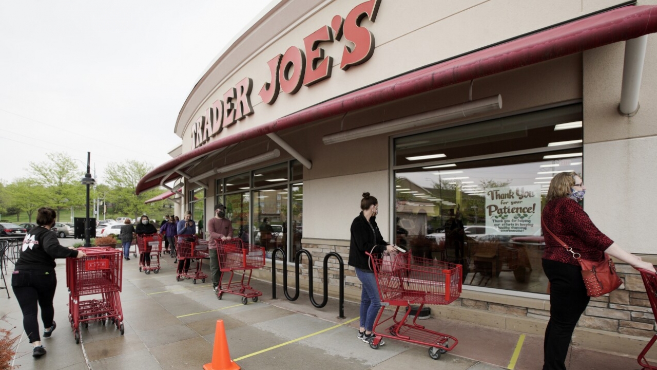Customers observe social distancing as they wait to be allowed to shop at a Trader Joe's supermarket.