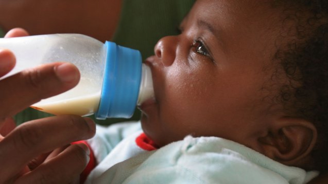 Baby drinking formula from a bottle.