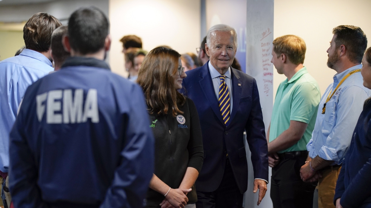 President Joe Biden walks with FEMA Associate Administrator of the Office of Response and Recovery Anne Bink.