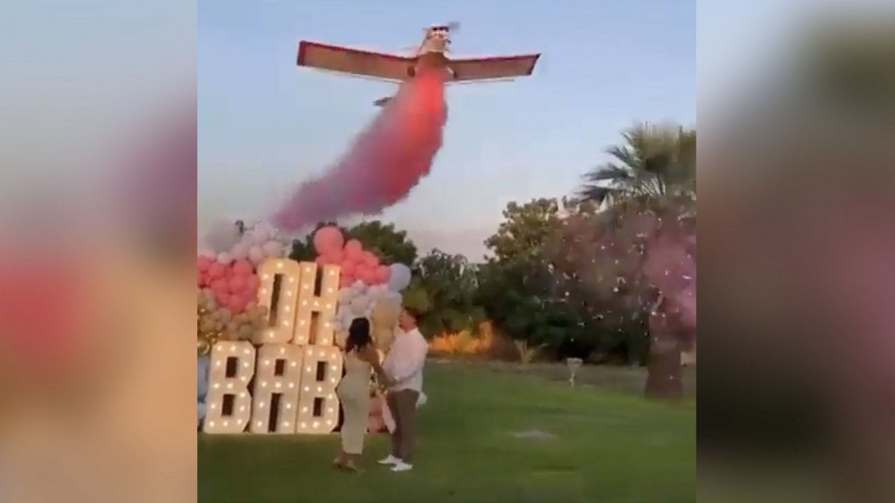 Plane flies with pink dust over couple during gender reveal