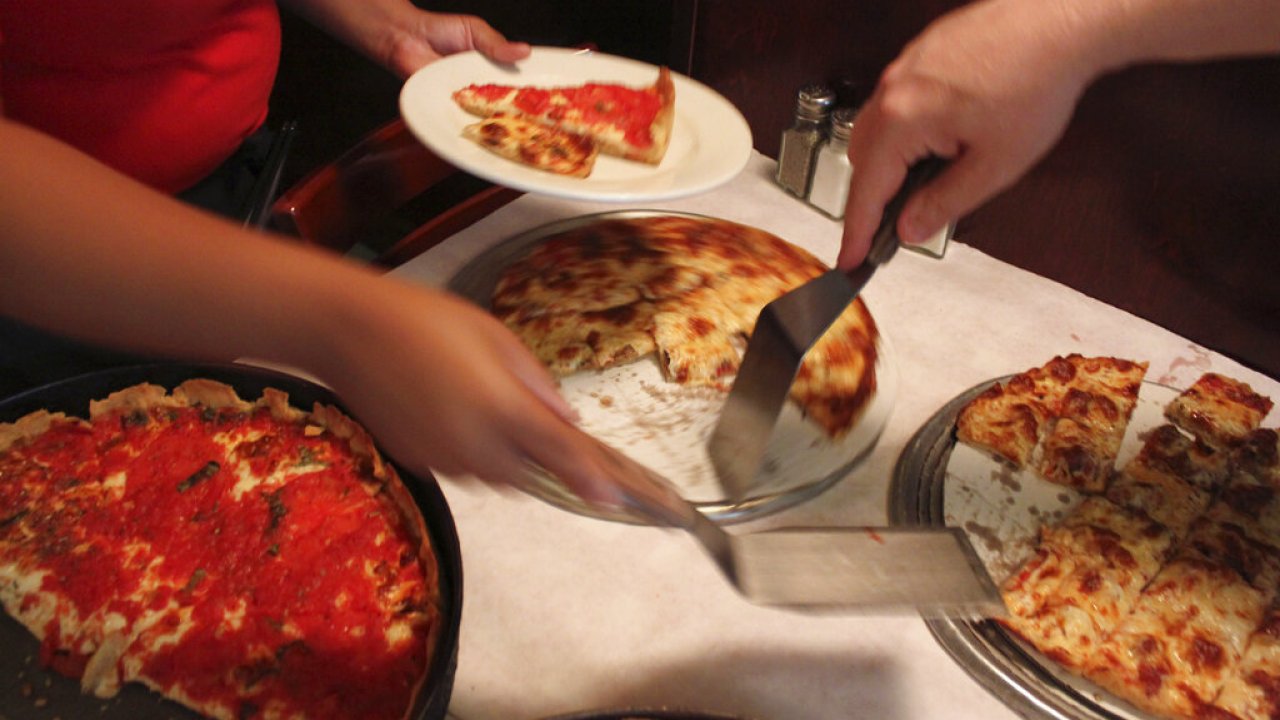 A waitress serves a cheese and sausage pizza to participants on a pizza tour at Pizano's in Chicago.