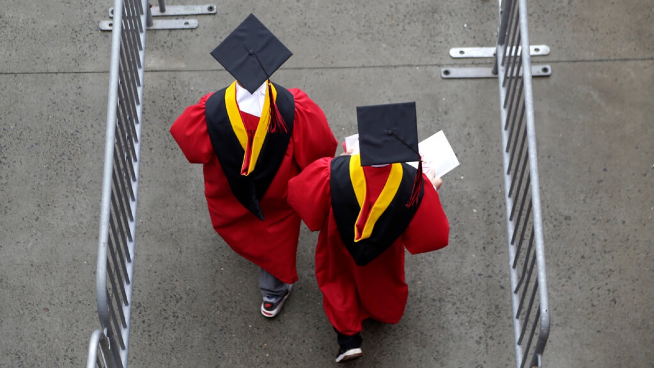 Graduates walk into a stadium before the start of the Rutgers University graduation ceremony