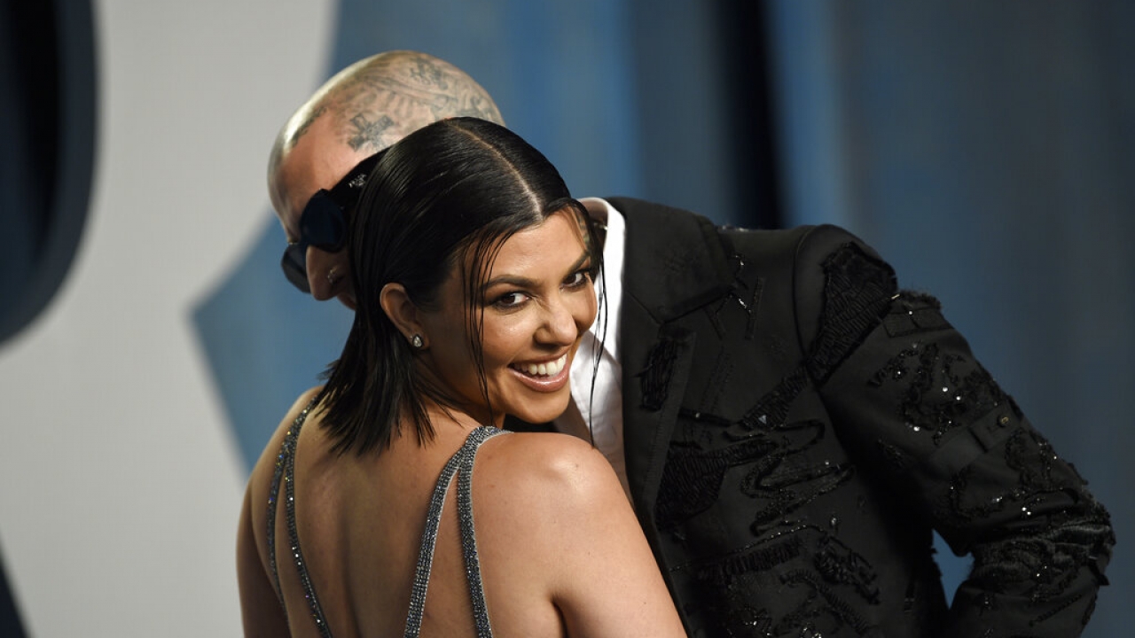 Kourtney Kardashian and Travis Barker pose on the red carpet.
