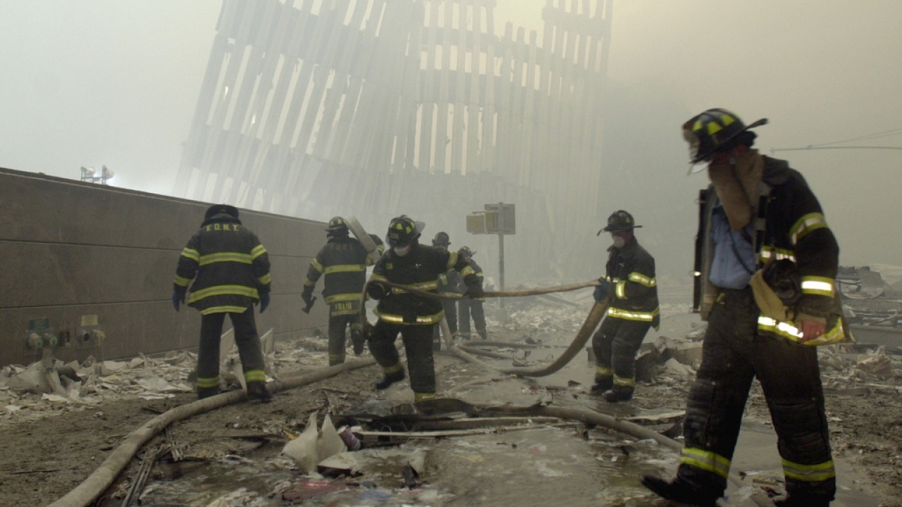 Firefighters search rubble in the aftermath of the 9/11 attacks