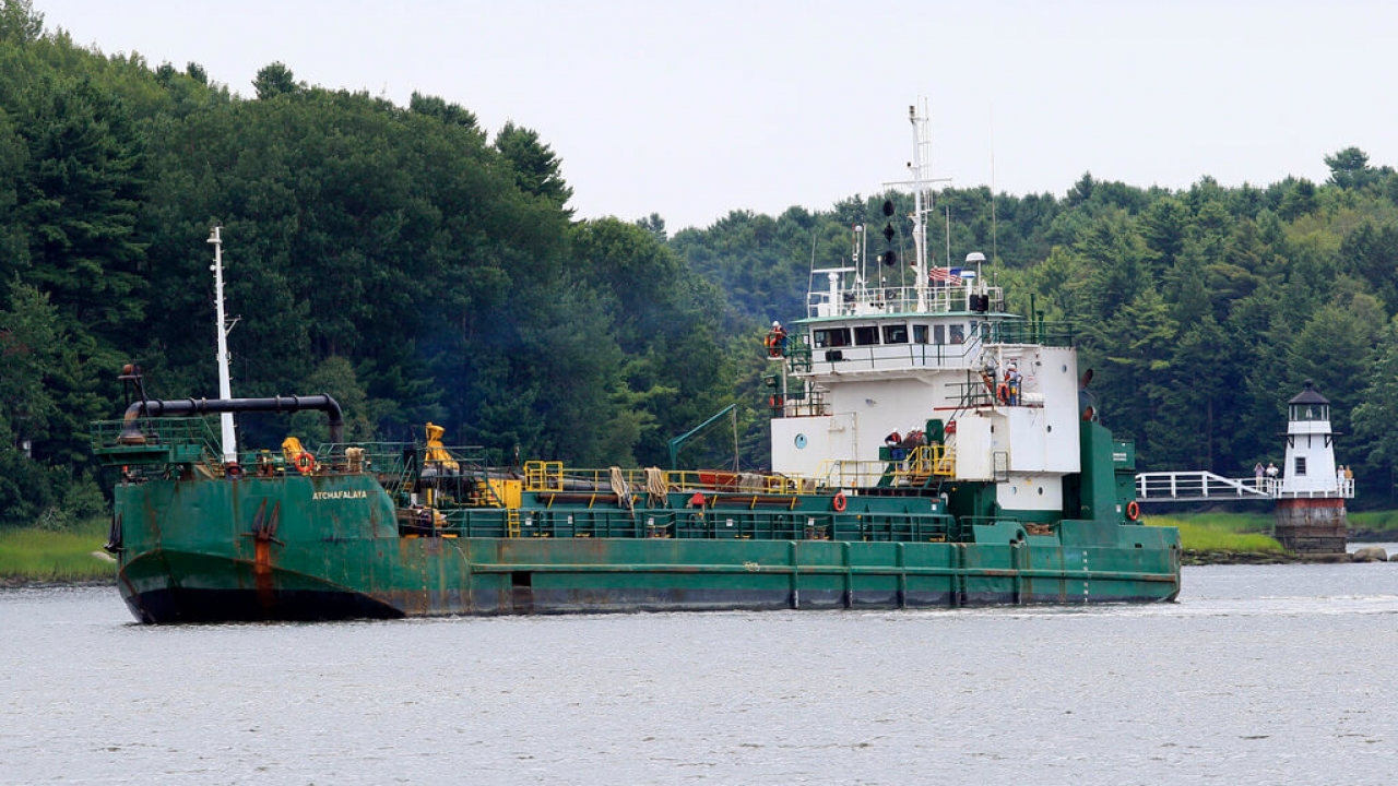 A dredger works to deepen a shallow channel in the Kennebec River.