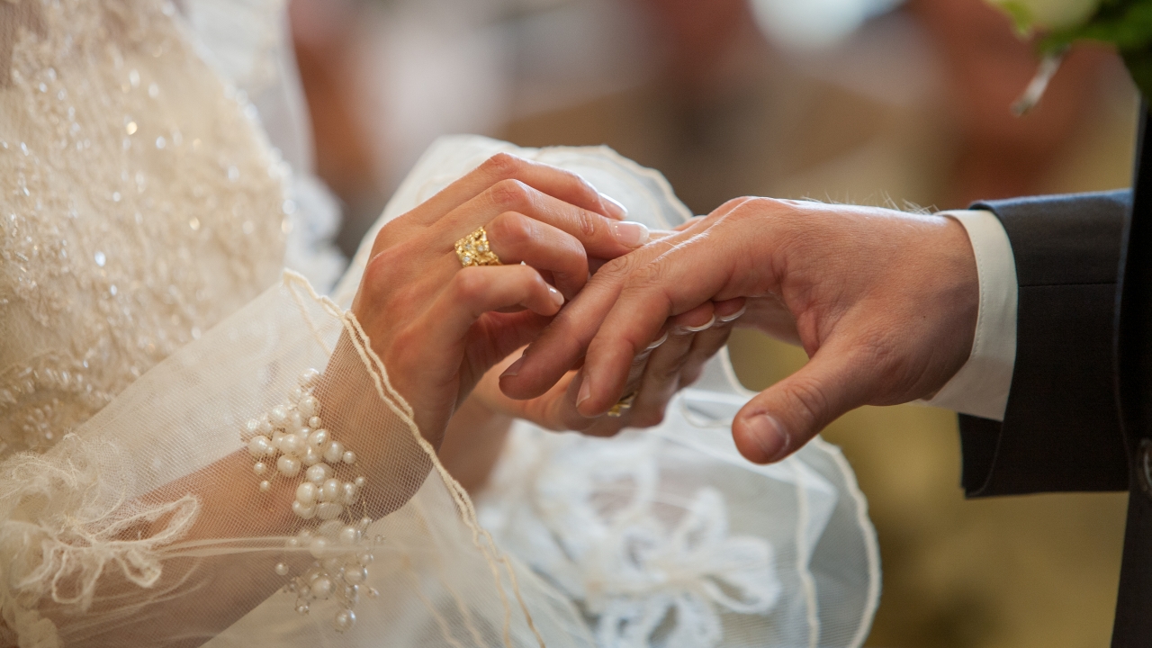 A ring is placed on someone's finger.