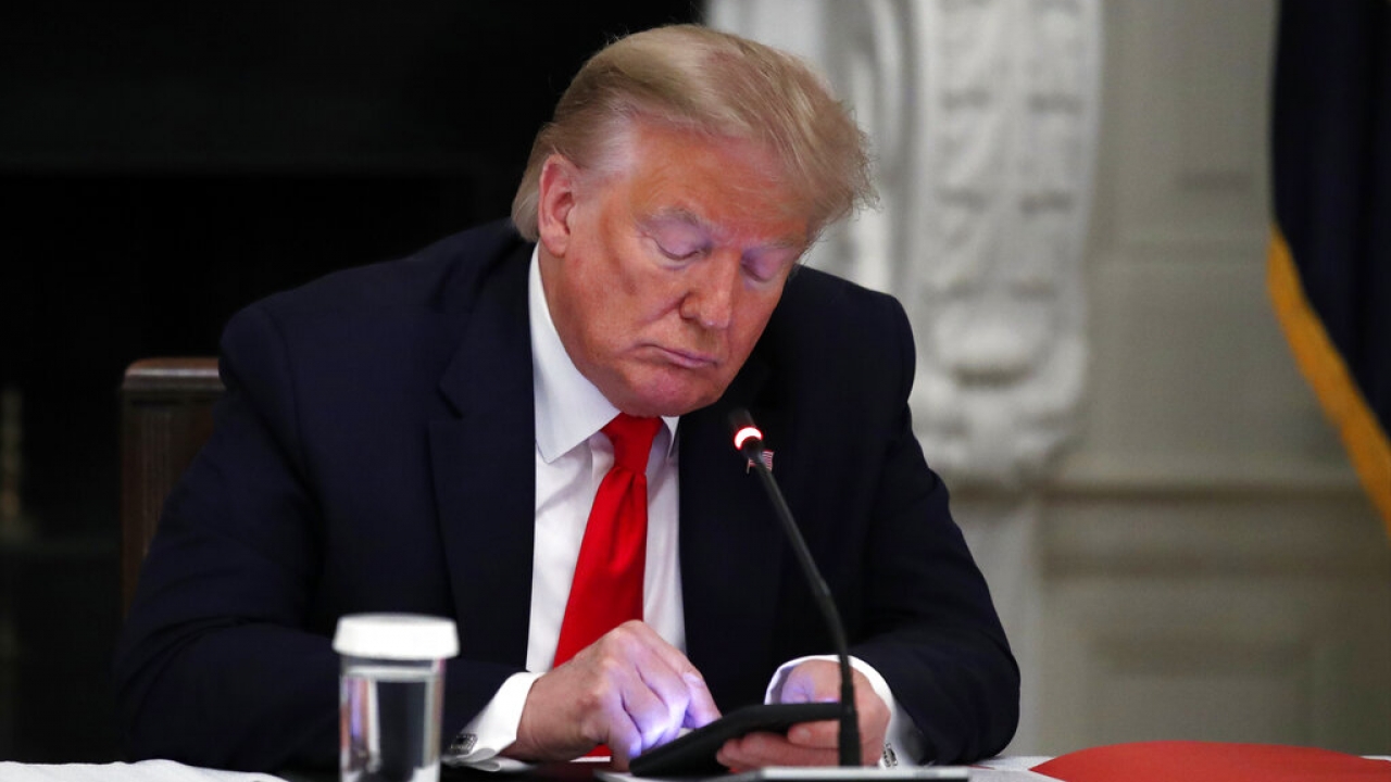 Former President Donald Trump using a cell phone.