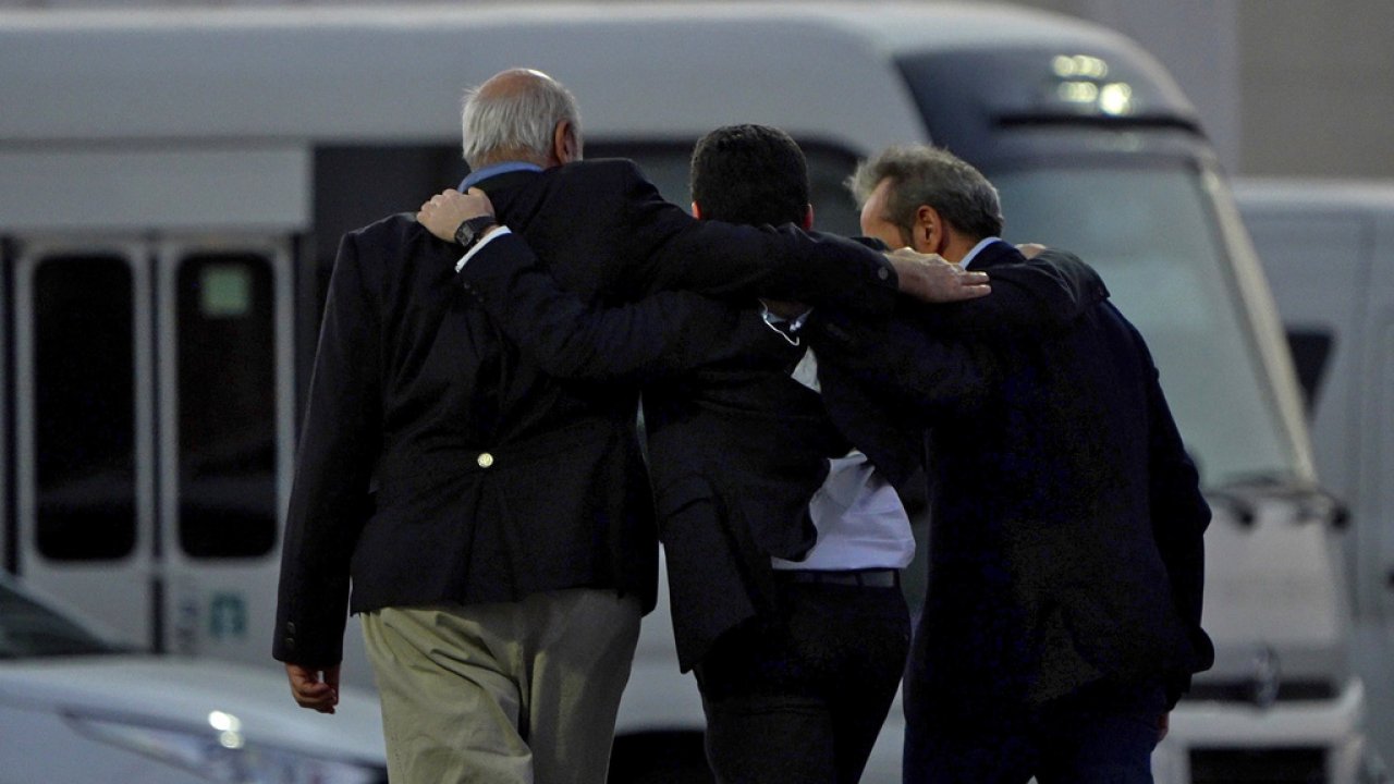 Americans walk away arm in arm from a Qatar Airways flight that brought them out of Tehran