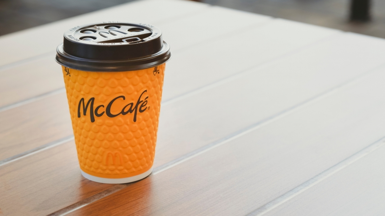 McDonald's coffee cup sitting on table.