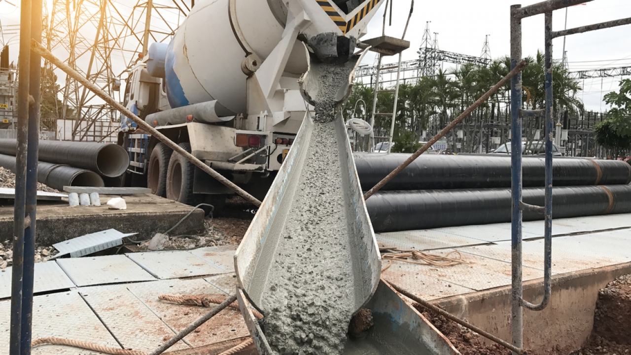A mixer truck unloads cement at a site.