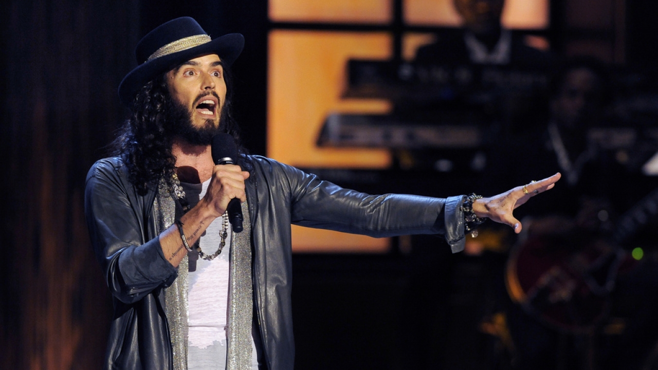 Russell Brand performs on stage.